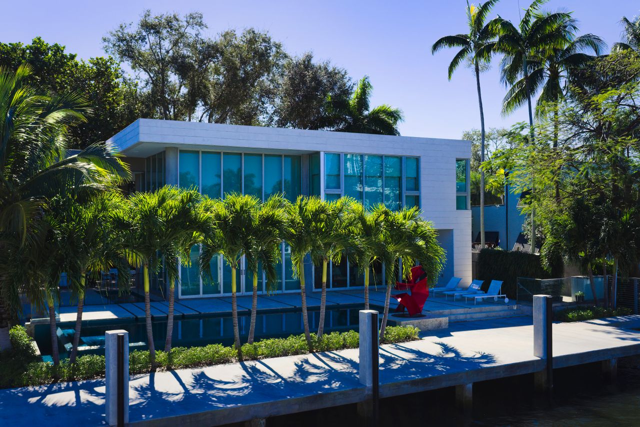 Elegant modern mansion in Fort Lauderdale, FL with pool and palm trees.